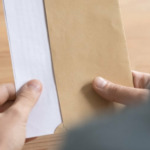 man holding envelope sent through a hybrid mail solution