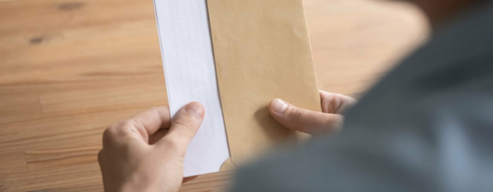 man holding envelope sent through a hybrid mail solution