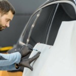 Employee wrapping a car with a vehicle livery