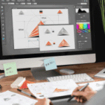 A person at a desk reviews printed charts and graphs, with a computer displaying similar designs and color palettes, suggesting a design or data visualization project for promotional merchandise or CDP insights.