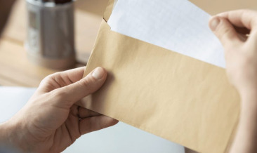 A person getting a letter from an envelope at the office