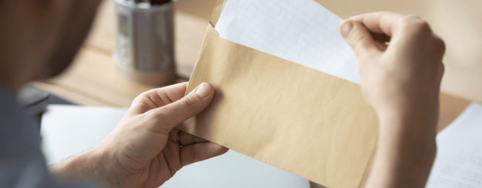 A person getting a letter from an envelope at the office